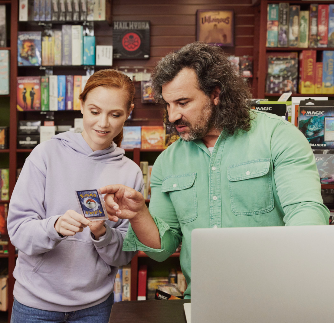 A gloved hand placing a baseball card into a protective sleeve